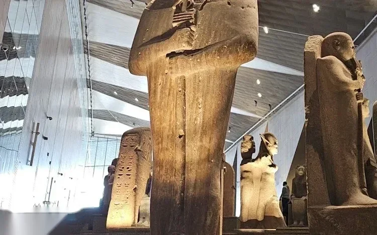 Close-up of large ancient Egyptian mummiform statues on display in the museum's grand hall.