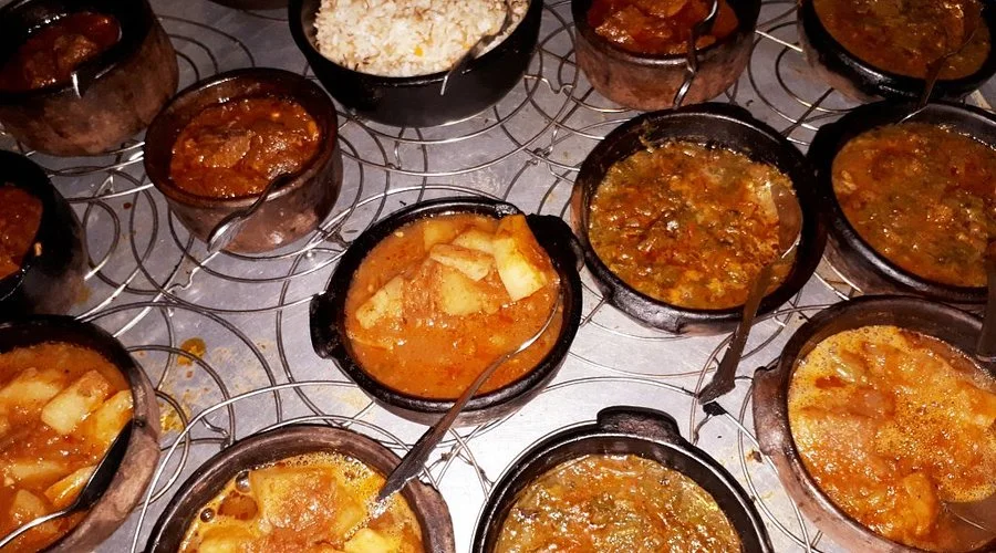 A spread of traditional Egyptian dishes in small clay pots, including rice, stews, and vegetables, served at the tour's lunch stop.