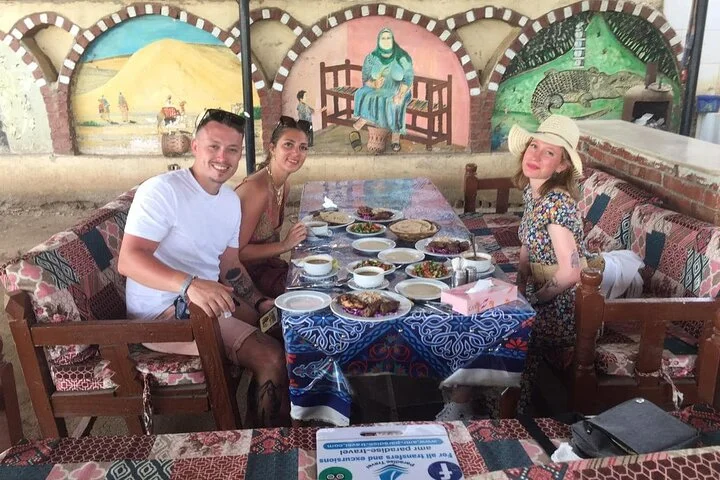 Guests seated at a decorated outdoor table enjoying lunch together during the tour's midday break.
