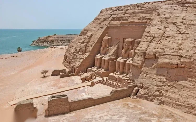 Elevated view of the Great Temple of Abu Simbel and the smaller Temple of Hathor beside it, both facing the lake.