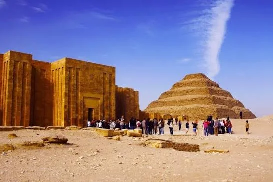 Tour group gathered outside the entrance colonnade of Djoser's funerary complex with the Step Pyramid behind them