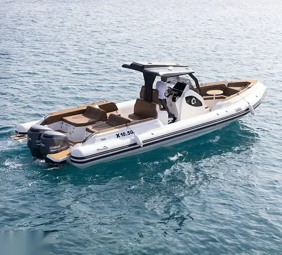 White rigid-hull inflatable speedboat with twin outboard engines cruising on calm turquoise water